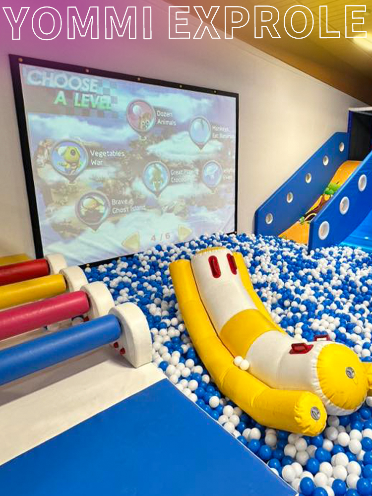 Interactive projection screen and floating soft obstacles inside a massive ball pool, designed to maximize engagement in an indoor playground.