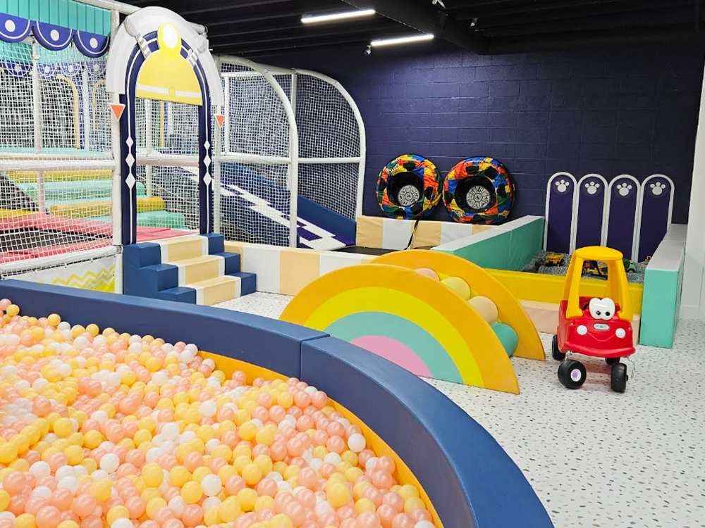 For the youngest visitors, we integrated deeply engaging, low-impact zones. A tactile sand pit and a charming toddler crawling area with a rainbow bridge provide safe spaces for early childhood exploration. Adjacent to this, the highly detailed pretend-play zones—featuring a beautifully crafted supermarket and play kitchen—invite children into immersive role-play.