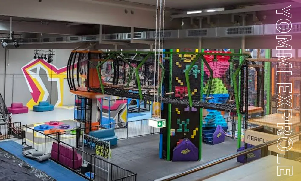 Indoor trampoline park ceiling showing massive HVAC ducts and lighting fixtures, illustrating the critical lowest obstacle point when calculating clear height requirements.