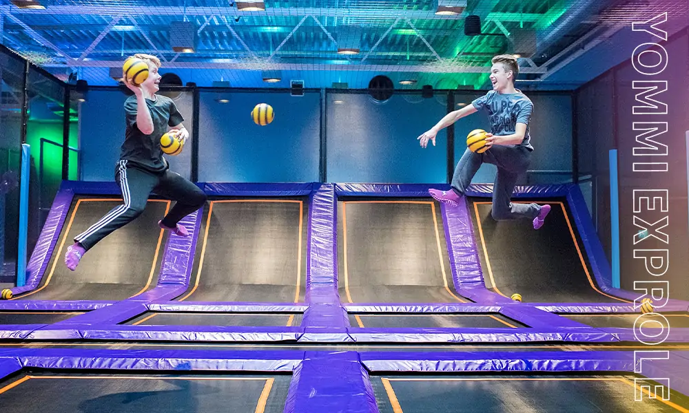 Young adults competing in a high-energy trampoline dodgeball match to drive weekday park revenue.