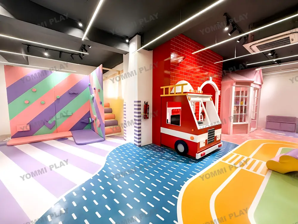 Role-play pretend play fire truck area in Babuland Banani indoor soft playground, colorful traffic pattern flooring and climbing wall for kids immersive imaginative play to extend family stay time